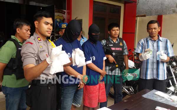 Pasutri penjual pil koplo saat diamankan. foto: ekoyono/ BANGSAONLINE