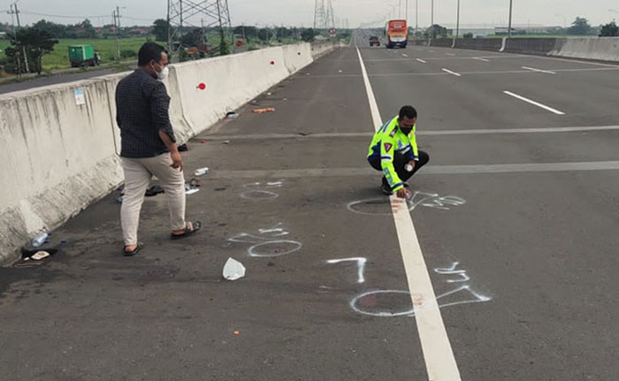 Petugas kepolisian saat melakukan olah TKP di Tol Japanan arah Sidoarjo.