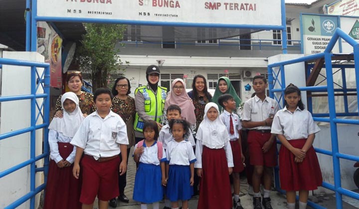 Seorang petugas Polresta Sidoarjo sedang bersama murid-murid salah satu sekolah SD.