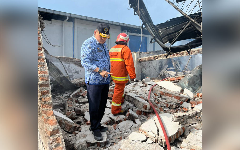 Kepala Dinas Damkar Gresik Agustin Halomoan Sinaga melihat puing-puing bangunan PT Rajasa Putra Jaya Perkasa usai terbakar. foto: IST./ BANGSAONLINE