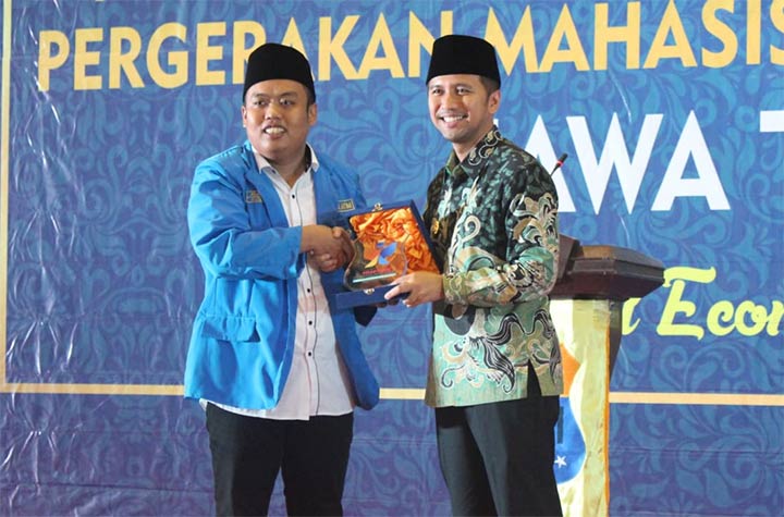 Ketua PKC PMII Jatim, Abdul Ghoni memberikan cinderamata kepada Wagub Jatim Emil Dardak. foto: DIDI ROSADI/ BANGSAONLINE