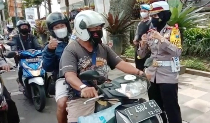 Kasatlantas AKP Indah Citra Fitriani saat memberikan hadiah kepada pengendara yang melintas di Jalan Diponegoro, Kota Batu.
