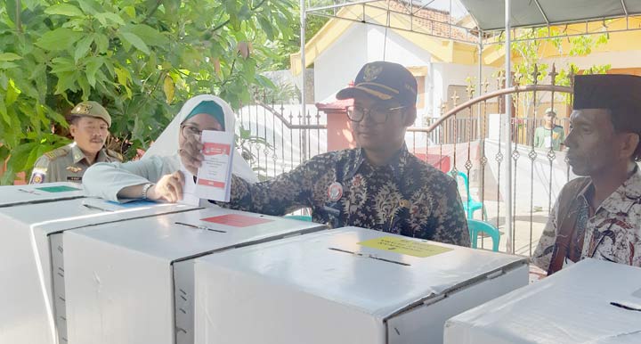 Bupati Bangkalan Abdul Latif Amin dan Istri saat menggunakan hak pilihnya di TPS 20 Kelurahan Semangan, Bangkalan. foto: AHMAD FAUZI/ BANGSAONLINE

