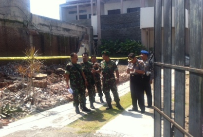 Petugas kepolisian saat melakukan olah TKP dilokasi hotel yang roboh menimpa dua pekerjanya hingga tewas. (foto: arif kurniawan/BANGSAONLINE)