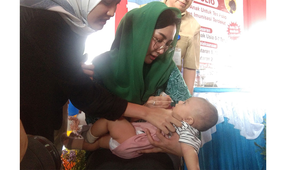 Pj Ketua Tim Penggerak PKK Nganjuk Eka Haryati Taruna saat meneteskan vaksin polio kepada salah satu balita.