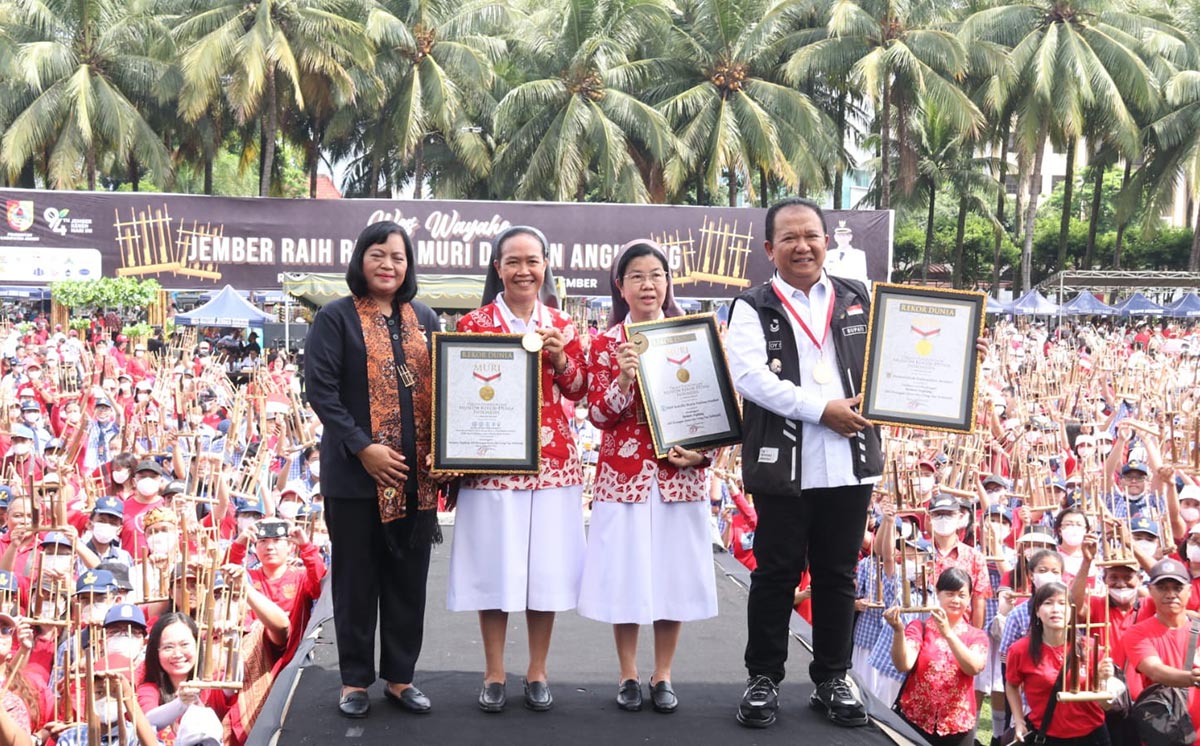 Bupati Jember Hendy Siswanto (kanan) menunjukkan piagam Muri atas permainan alat musik angklung dengan jumlah pasangan terbanyak.