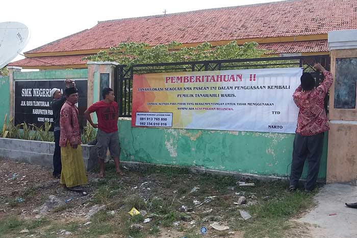 Pemasangan banner somasi di pagar SMKN 1 Pasean.