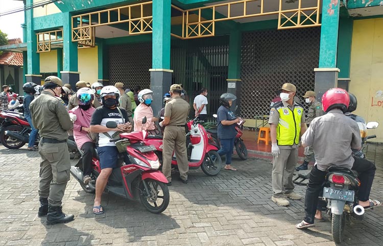 Petugas Gabungan Kabupaten Sidoarjo saat melakukan razia terhadap para pelanggar PSBB (Pembatasan Sosial Berskala Besar) di Sidoarjo.