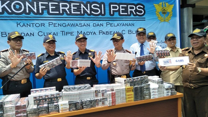 Petugas saat menunjukkan barang bukti rokok ilegal sebelum dimusnahkan.