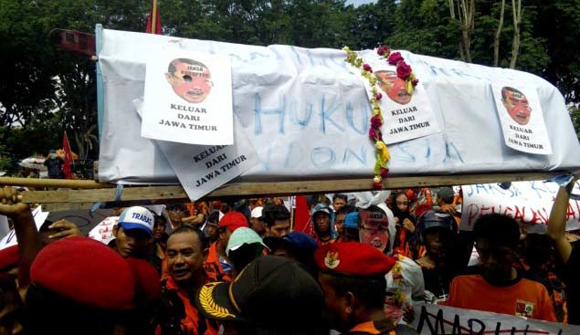 Massa berseragam Pemuda Pancasila mengusung keranda saat aksi demo di depan Kantor Kejati Jatim, Senin (21/3). foto: mtrv
