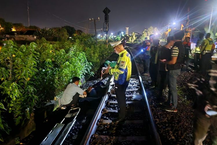 Polisi saat mendatangi lokasi penemuan mayat tergeletak di pinggir rel kereta api pada titik KM 187+5 petak jalan Lamongan-Surabayan