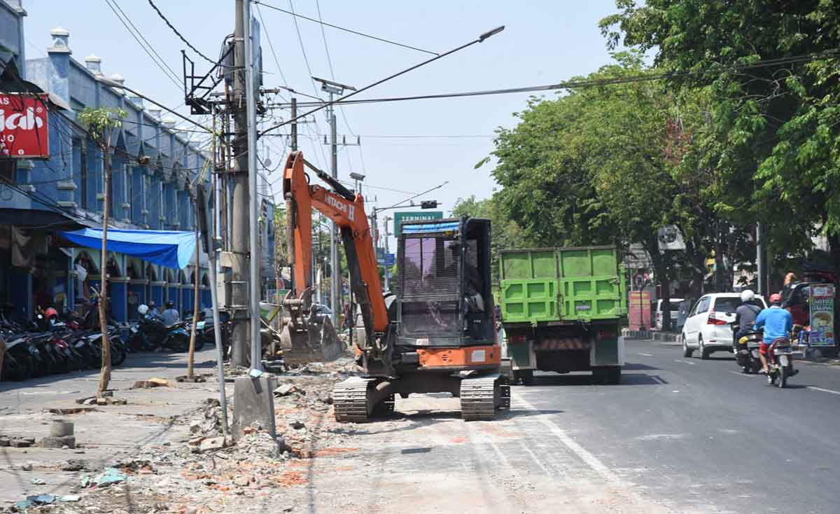 Pekerja memakai alat berat mulai membongkar pagar Pasar Larangan, Sidoarjo. Nantinya, lokasi ini bakal dibangun taman.