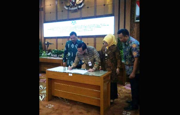 Bupati Sambari didampingi Wakil Ketua DPRD Nur Saidah dan pejabat Forkopimda saat teken berita acara penyerahan pengelolaan SLTA. foto: SYUHUD/ BANGSAONLINE