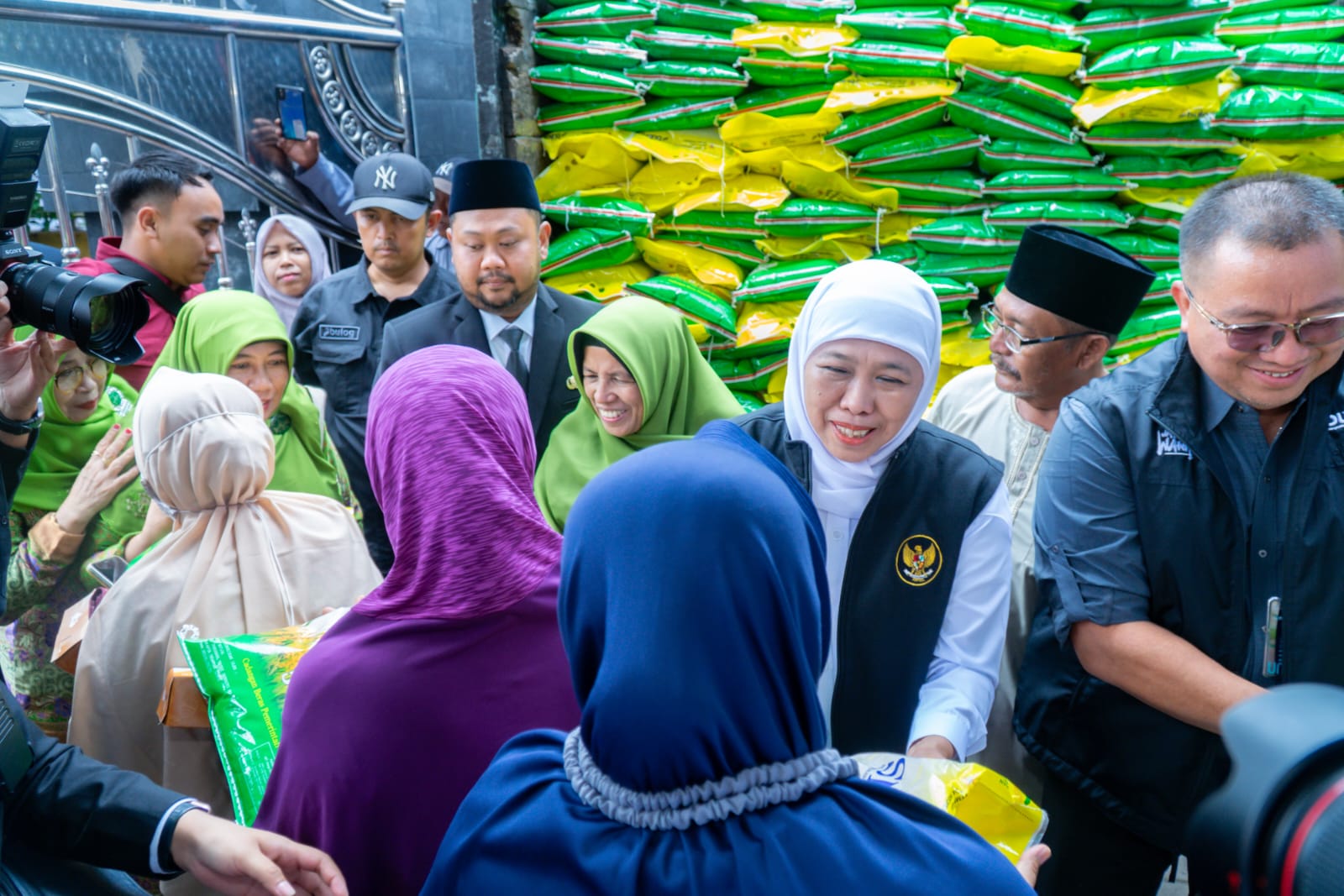 Gubernur Jatim Khofifah Indar Parawansa didampingi Bupati Fandi Akhmad Yani saat menyerahkan beras kepada warga di Pasar Murah Desa Banjarsari.