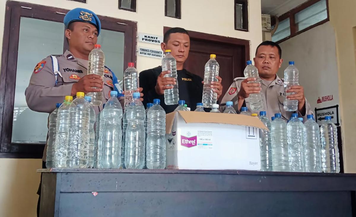 Petugas Polsek Ngancar saat menunjukkan barang bukti berupa 35 botol miras jenis arak jowo. Foto: Ist.