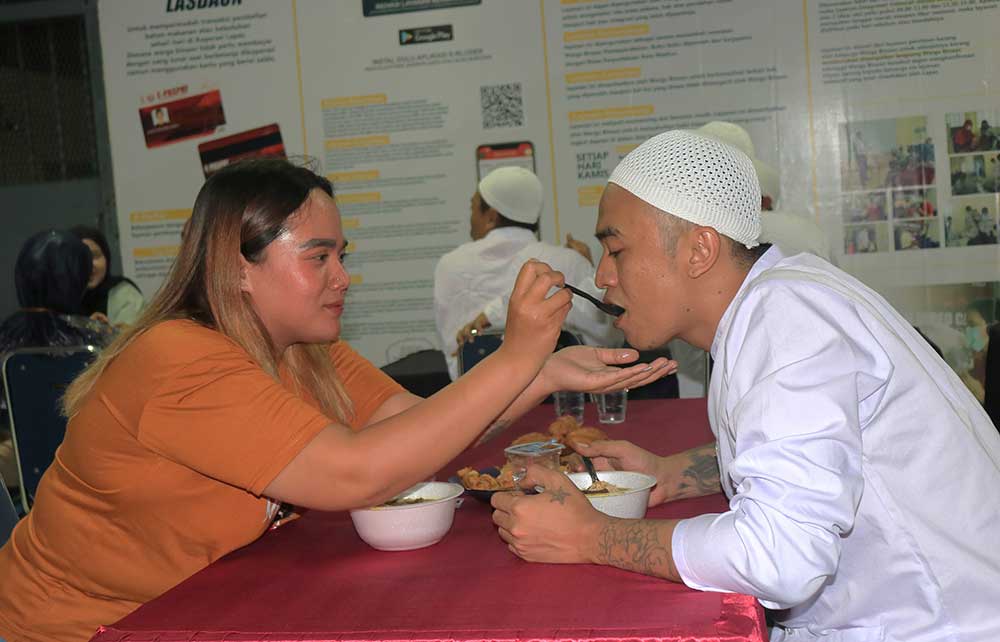 Salah satu warga binaan Lapas Pemuda Kelas II A Madiun disuapi istrinya saat acara buka bersama. Foto: HENDRO SUHARTONO/ BANGSAONLINE
