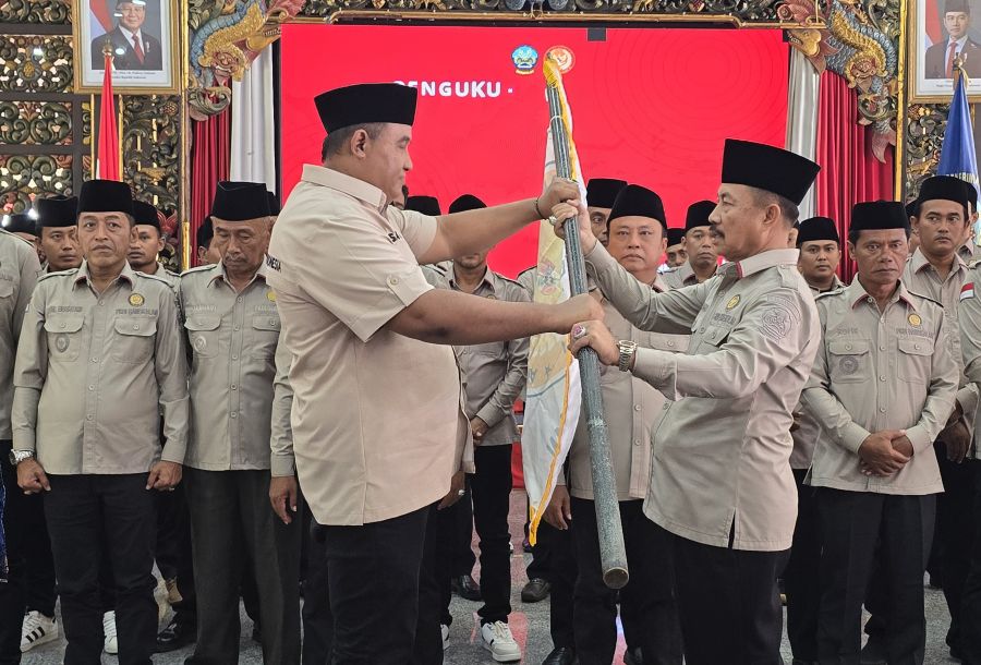 Sekretaris DPD PKDI Jawa Timur Sandy (kiri) saat memberikan bendera pataka kepada ketua DPC PKDI Bangkalan, H. Marhayat.