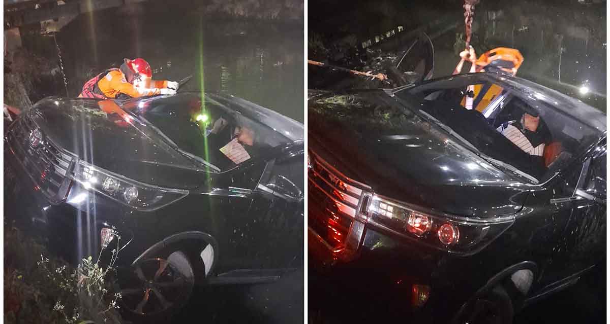 Petugas saat mengevakuasi mobil yang tercebut di kali depan RS Ubaya.