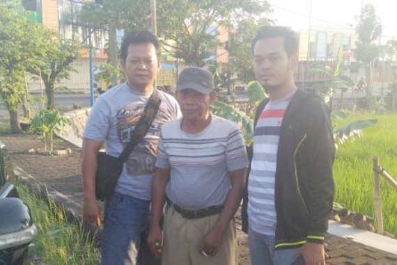 Surongolo diapit dua petugas kepolisian yang menangkapnya. 