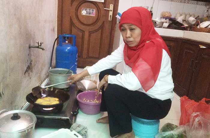 Khofifah Indar Parawansa sedang memasak di rumah.