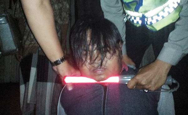 Pelaku diamankan petugas usai dihajar massa. 