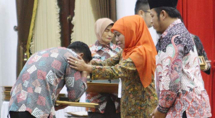 Gubernur Khofifah Indar Parawansa didampingi Ketua KPU Jatim Choirul Anam menyerahkan santunan kepada keluarga petugas penyelenggara pemilu yang wafat saat menjalankan tugas pada Pemilu 17 April. foto: ist
