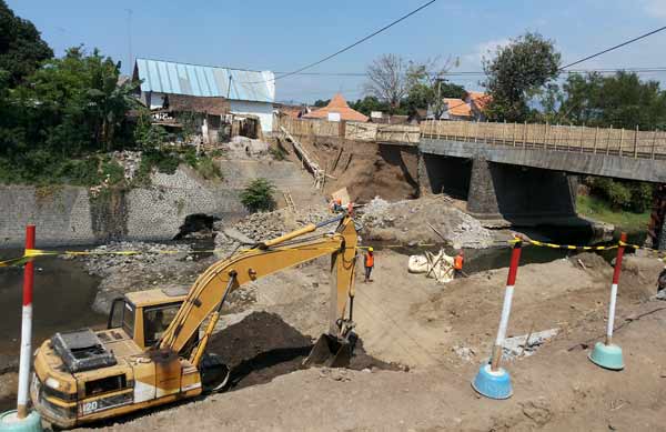 Tampak ada aktivitas alat berat yang bekerja meskipun proyek dihentikan oleh polisi dalam seminggu ke depan. (foto: andi/BANGSAONLINE)