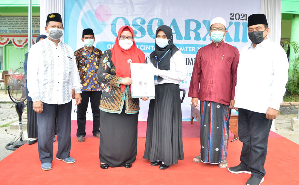 Wabup Bu Min menyerahkan beasiswa kepada mahasiswa berprestasi. foto: SYUHUD/ BANGSAONLINE