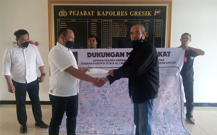 Ketua Orkemas IDR, Choirul Anam (kanan), saat menyerahkan tanda tangan dukungan kepada Kanit Tipikor Satreskrim Polres Gresik, Ipda I Ketut Raisa. Foto: Ist