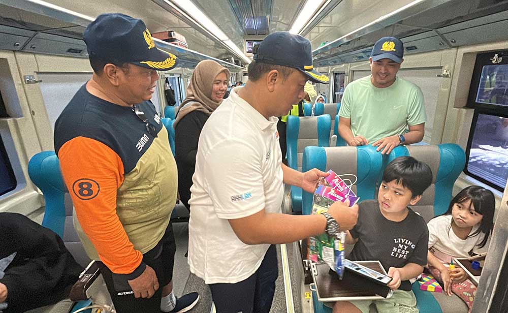 Petugas memberikan suvenir kepada penumpang anak-anak.