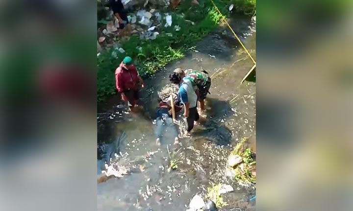 Warga mengevakuasi korban dari Sungai Brantas untuk diserahkan pada keluarganya.