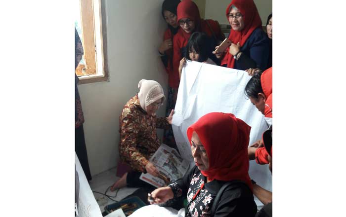 Ketua DPC Sarinah Gresik Siti Muafiyah bersama Wali Kota Surabaya Tri Rismaharini saat belajar membatik. foto: SYUHUD/ BANGSAONLINE