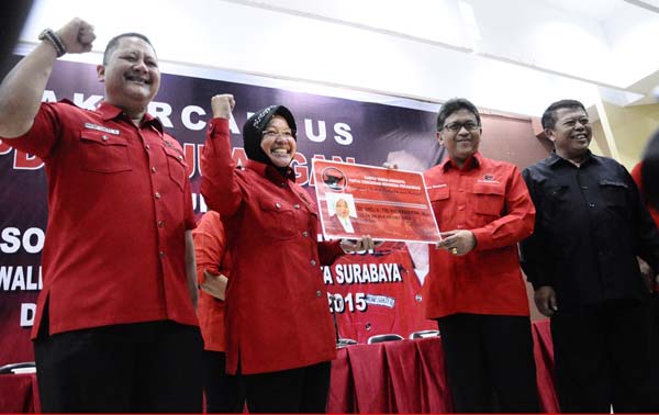 Sekjen DPP PDIP Hasto Kristianto menunjukkan KTA PDIP milik Tri Rismaharini. Tampak disampingnya Whisnu Sakti Buana. (maulana/BANGSAONLINE)