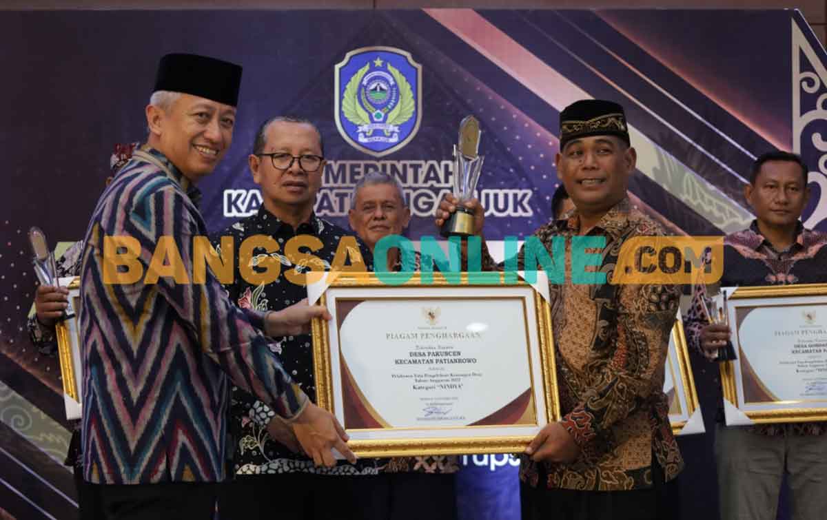 Pj Bupati Nganjuk, Sri Handoko Taruna, saat memberikan piagam kepada desa pemenang kategori Nindya. Foto: BAMBANG DWI JULIANTO/BANGSAONLINE