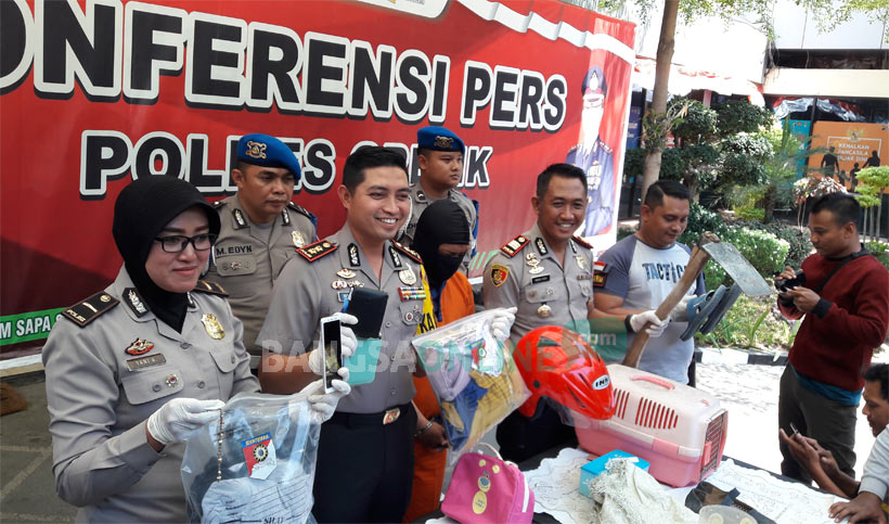 Kapolres AKBP Wahyu S Bintoro memamerkan tersangka beserta HP dan baju milik korban. foto: SYUHUD/ BANGSAONLINE