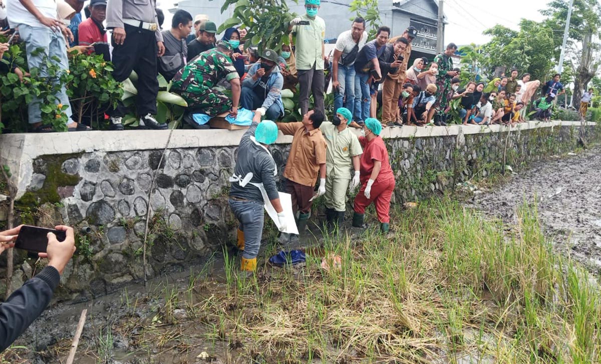 Petugas saat mengevakuasi jasad bayi yang ditemukan di pinggir sawah.