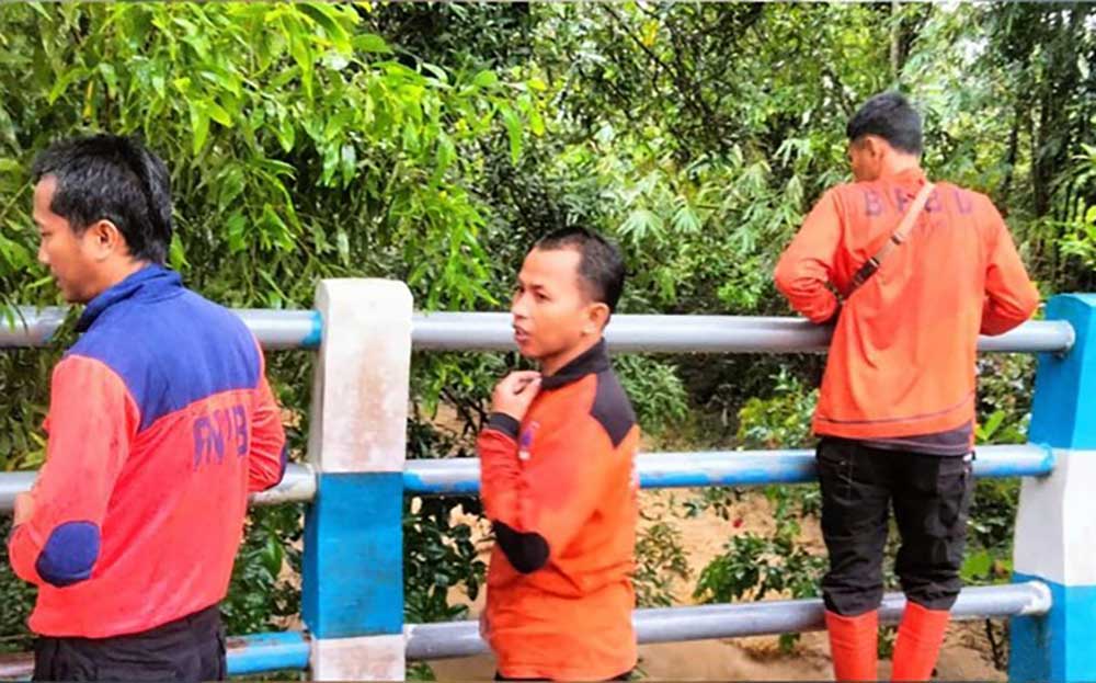 Petugas BPBD Pamekasan mengamati sungai untuk mencari keberadaan korban.