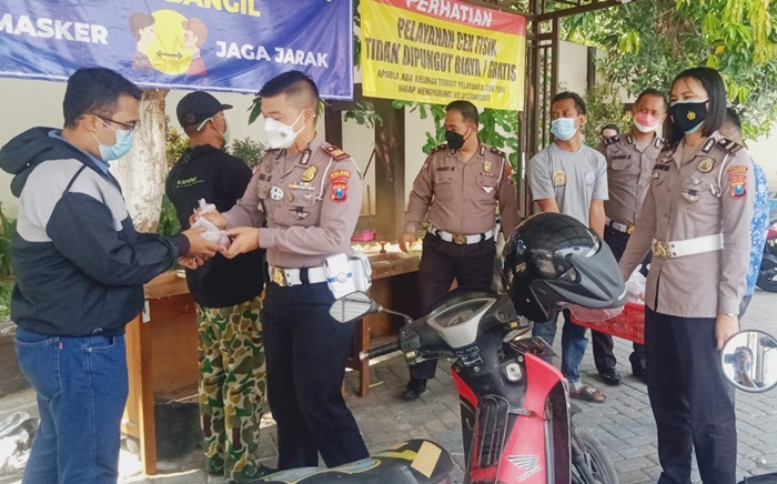 Anggota Satlantas Polres Pasuruan memberikan bubur kacang ijo dan telur rebus kepada para wajib pajak.