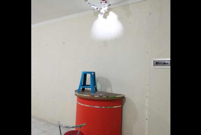 Plafon konter tampak berlubang setelah dijebol oleh pelaku sebagai jalan masuk.