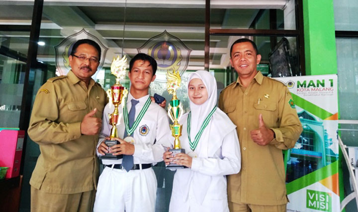 Kepala MAN 1 Kota Malang H. M. Husnan didampingi Waka Kesiswaan Iwan Setiawan, mengapit dua siswa juara pencak silat internasional di ITB Bandung. foto: IWAN IRAWAN/ BANGSAONLINE