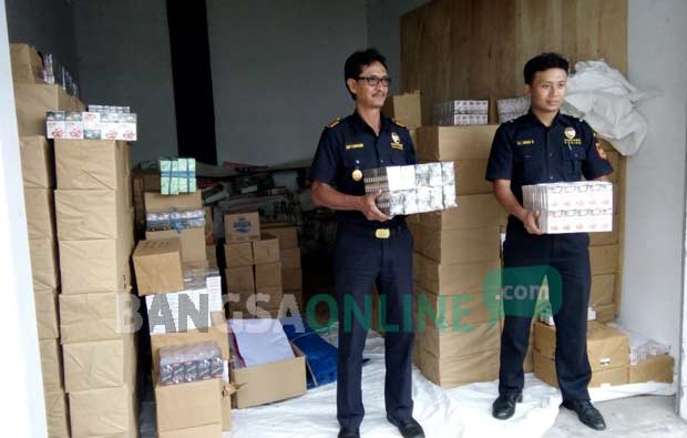 Petugas menunjukkan rokok ilegal yang berhasil disita Kantor Pengawasan dan Pelayanan Bea Cukai Tipe Pratama Blitar. foto: AKINA/ BANGSAONLINE