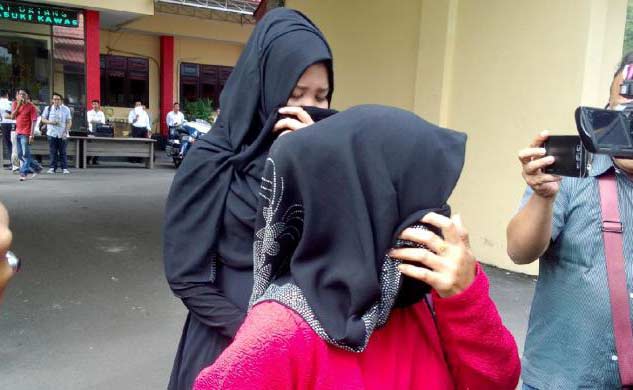 Mafeni (berpakaian hitam-hitam) saat keluar dari gedung Ditreskrimum Polda Jatim, Senin (24/10).