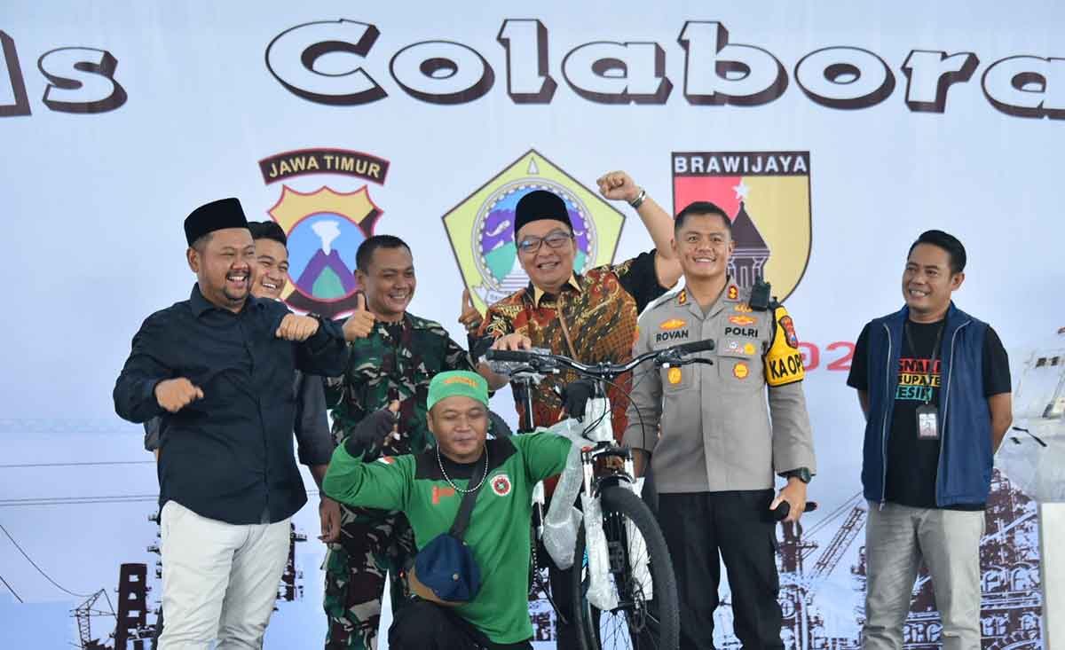 Bupati Gresik Fandi Akhmad Yani, Wabup Asluchul Alif, Kapolres AKBP Rovan Richard Mahenu, serta Ketua DPRD M. Syahrul Munir saat menyerahkan hadiah doorprize berupa sepeda dalam peringatan May Day 2025. Foto: Ist.