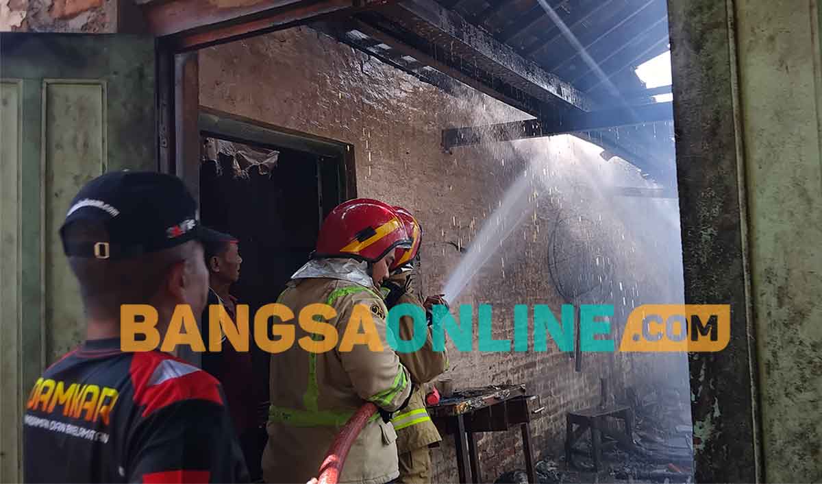 Para petugas Damkar Kabupaten Madiun saat memadamkan api yang membakar pabrik kerupuk. Foto: HENDRO SUHARTONO/BANGSAONLINE