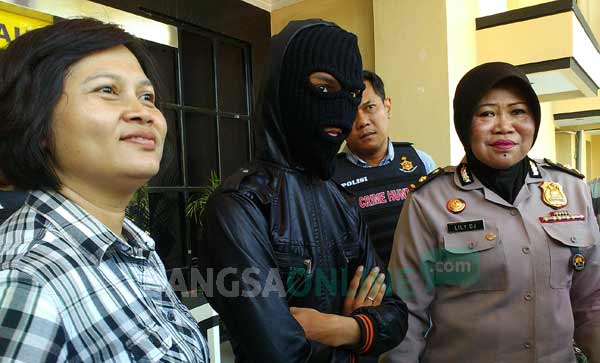 Tersangka cabul di bawah umur didampingi Kasubag Humas Polrestabes. foto: ekoyono/ BANGSAONLINE