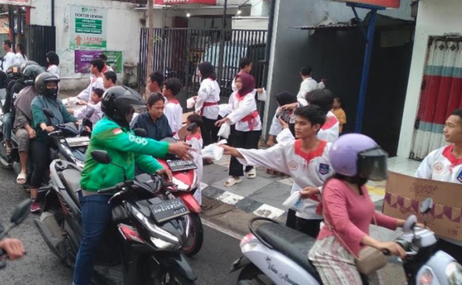 Anggota Merpati Putih saat bagi-bagi takjil kepada pengguna jalan. (Ist).