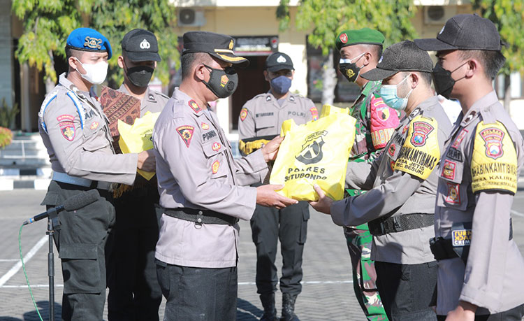 Wakapolres Situbondo menyerahkan bantuan beras secara simbolis kepada kapolsek jajaran untuk disebar kepada warga. (foto: ist)