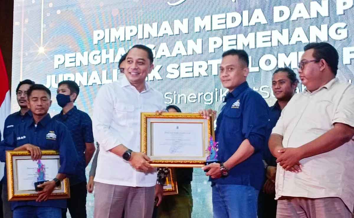 Wartawan HARIAN BANGSA, Yudi Arianto, saat menerima piagam penghargaan dan trofi dari Wali Kota Surabaya, Eri Cahyadi. Foto: Ist