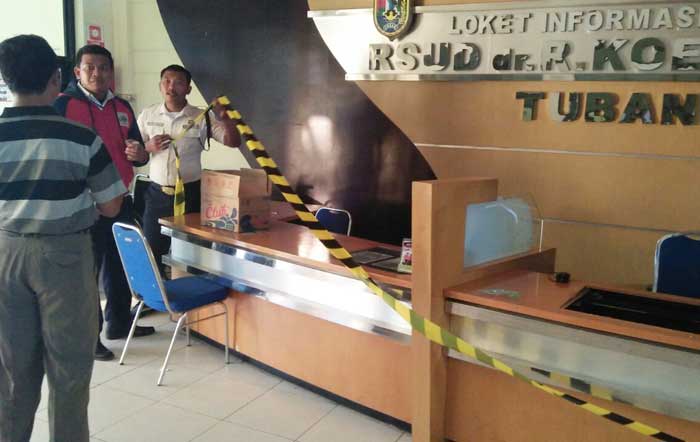 Petugas saat memasang police line.