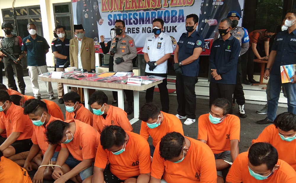Anggota DPRD Nganjuk Ibnu Khajar (dua dari kanan di barisan belakang) saat dihadirkan dalam rilis pers di Mapolres Nganjuk bersama tersangka kasus narkotika lainnya. foto: RAFLI FAJRI JULIANTO/ BANGSAONLINE